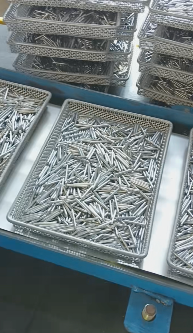 Close view of elongated metal components in mesh trays